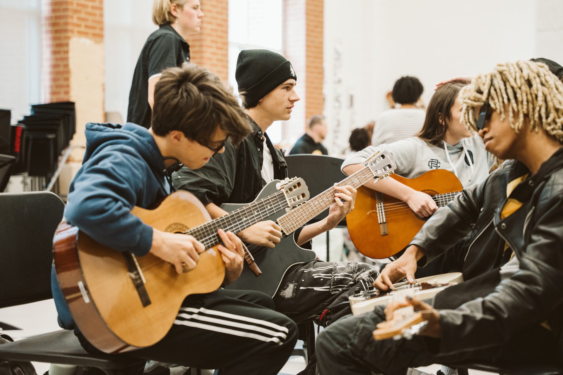 Young students playing acoustic guitars up close